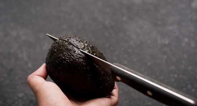 Cut a ripe avocado in half.